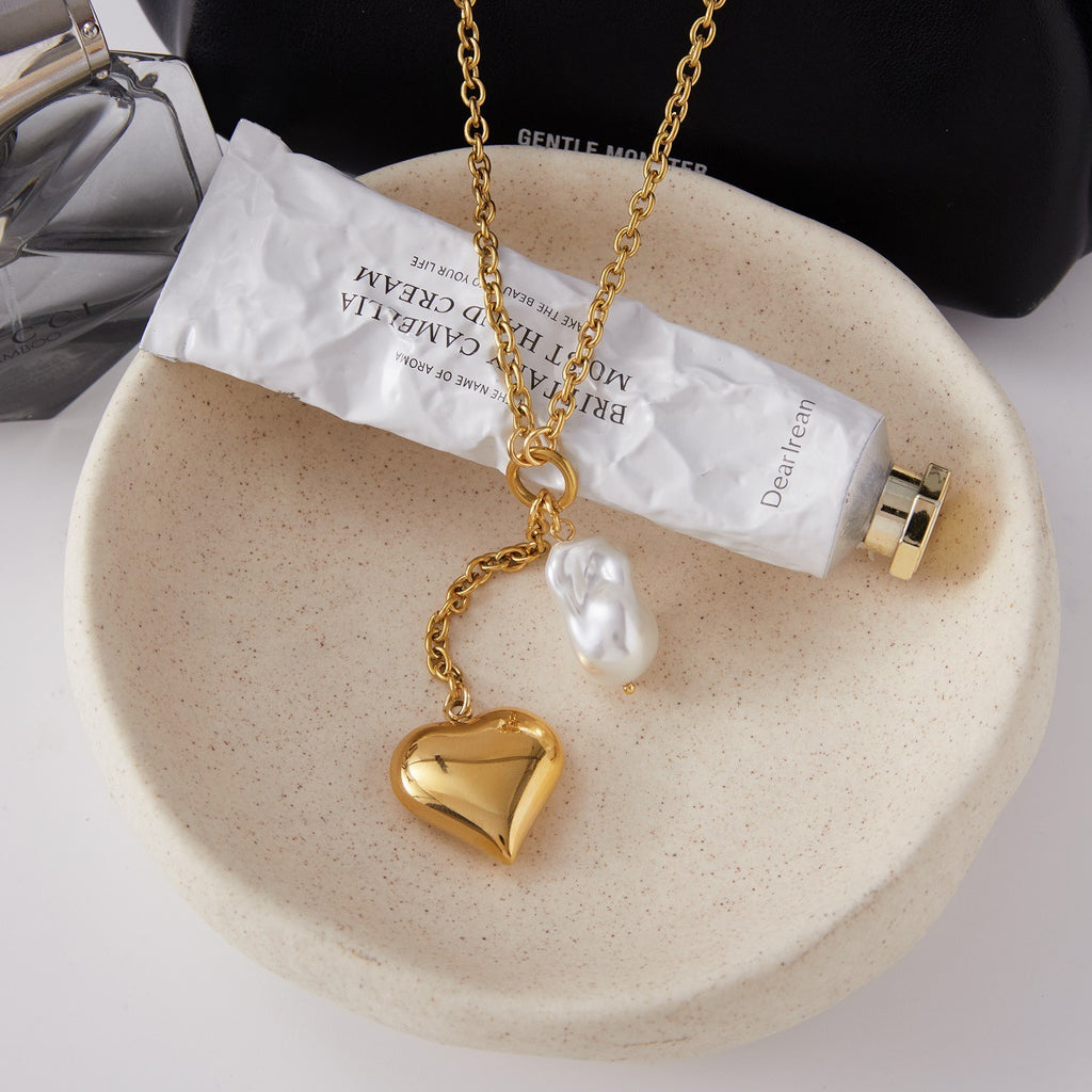 Heart locket Y necklace displayed on a fabric tray