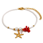 isolated gold plated stainless steel starfish bracelet with red and white beads