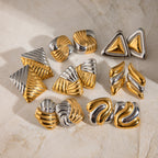 Ridged and folded stainless steel earring styles displayed on fabric