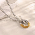 two-tone stainless steel toggle pendant necklace on a pale surface