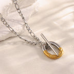 two-tone stainless steel toggle pendant necklace on a pale surface