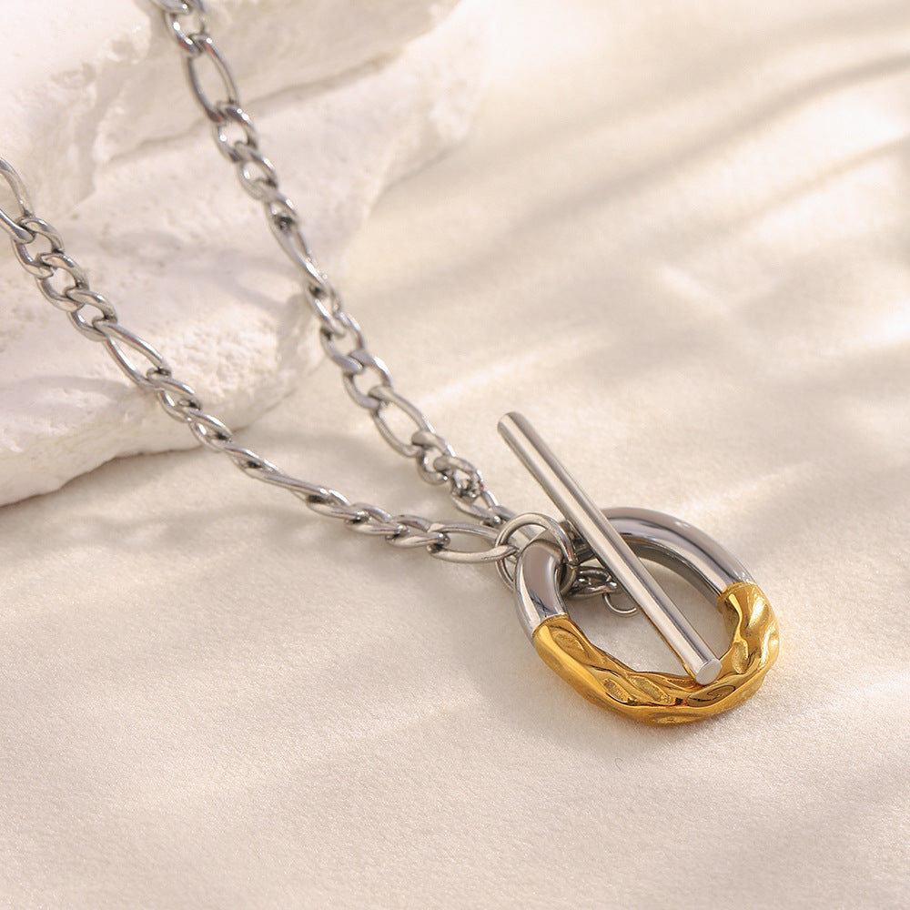 two-tone stainless steel toggle pendant necklace on a pale surface