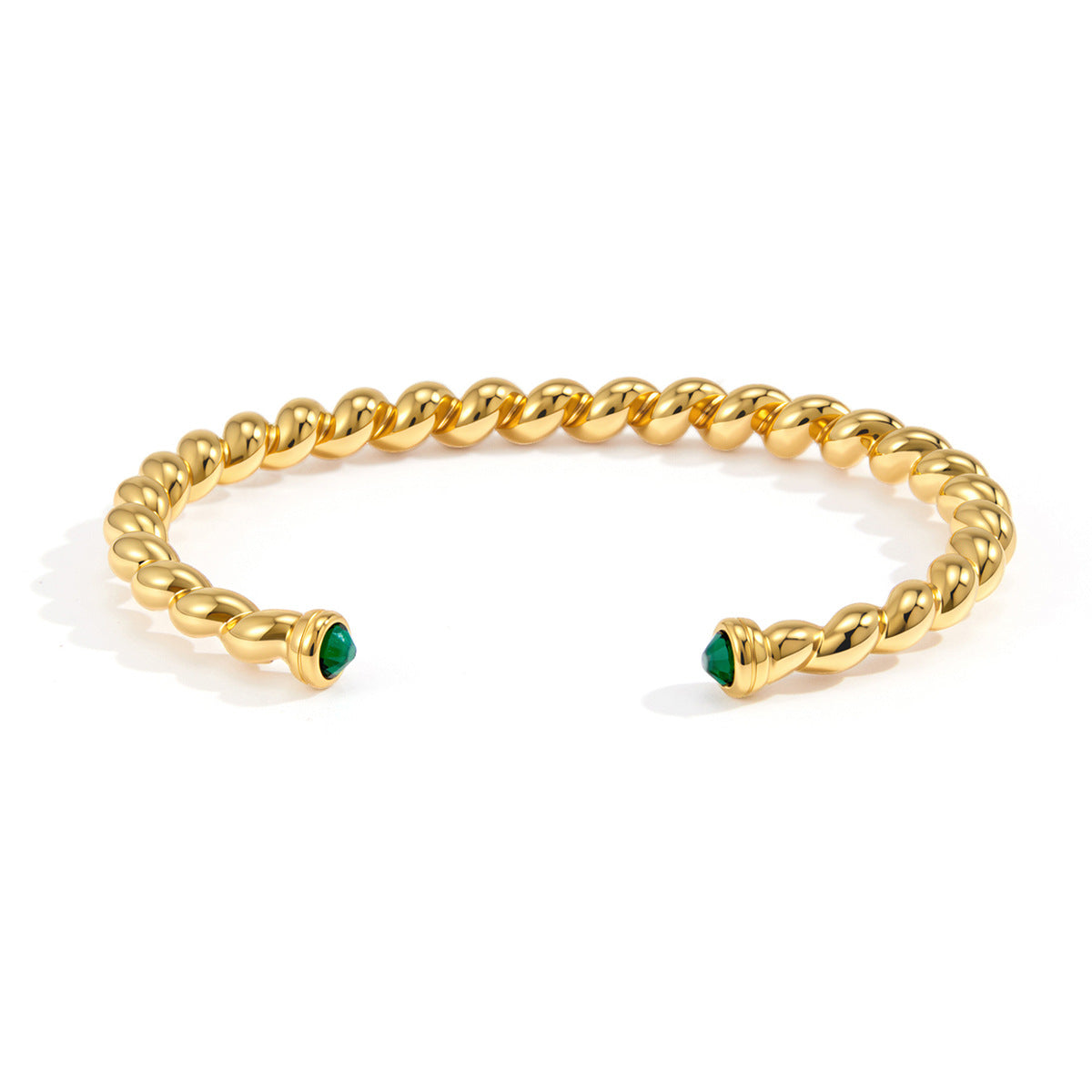 Front view of twisted stainless steel cuff with green stone terminals