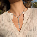 clear-stone Y necklace with asymmetric drops worn on model