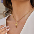 gold plated safety pin cross charm necklace worn on model