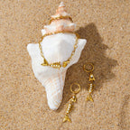 Fishbone jewelry arranged beside a spiral shell