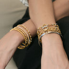 Chain bracelets and stone bangles worn on both wrists