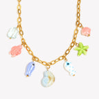 isolated gold plated necklace with seven colorful ocean charms