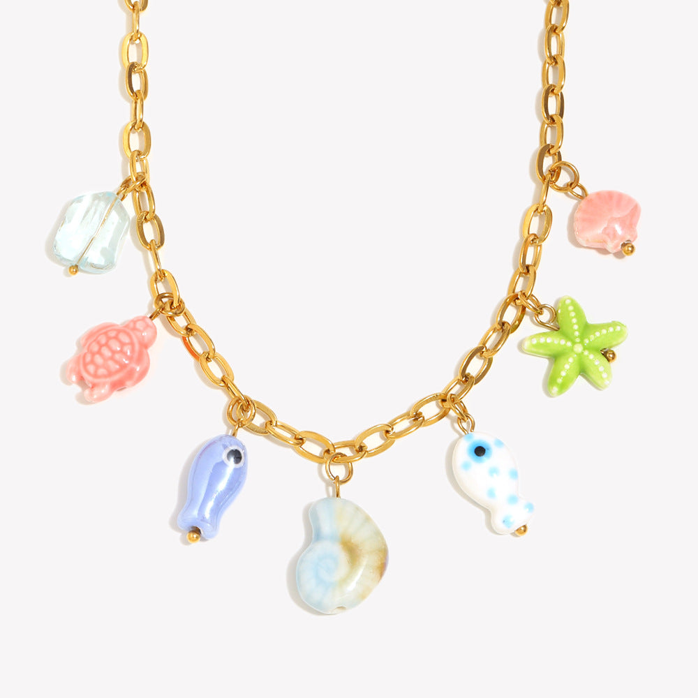 isolated gold plated necklace with seven colorful ocean charms