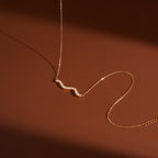clear-stone double-wave necklace in warm light