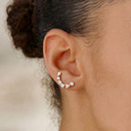 Gold tone curved stone stud worn in profile
