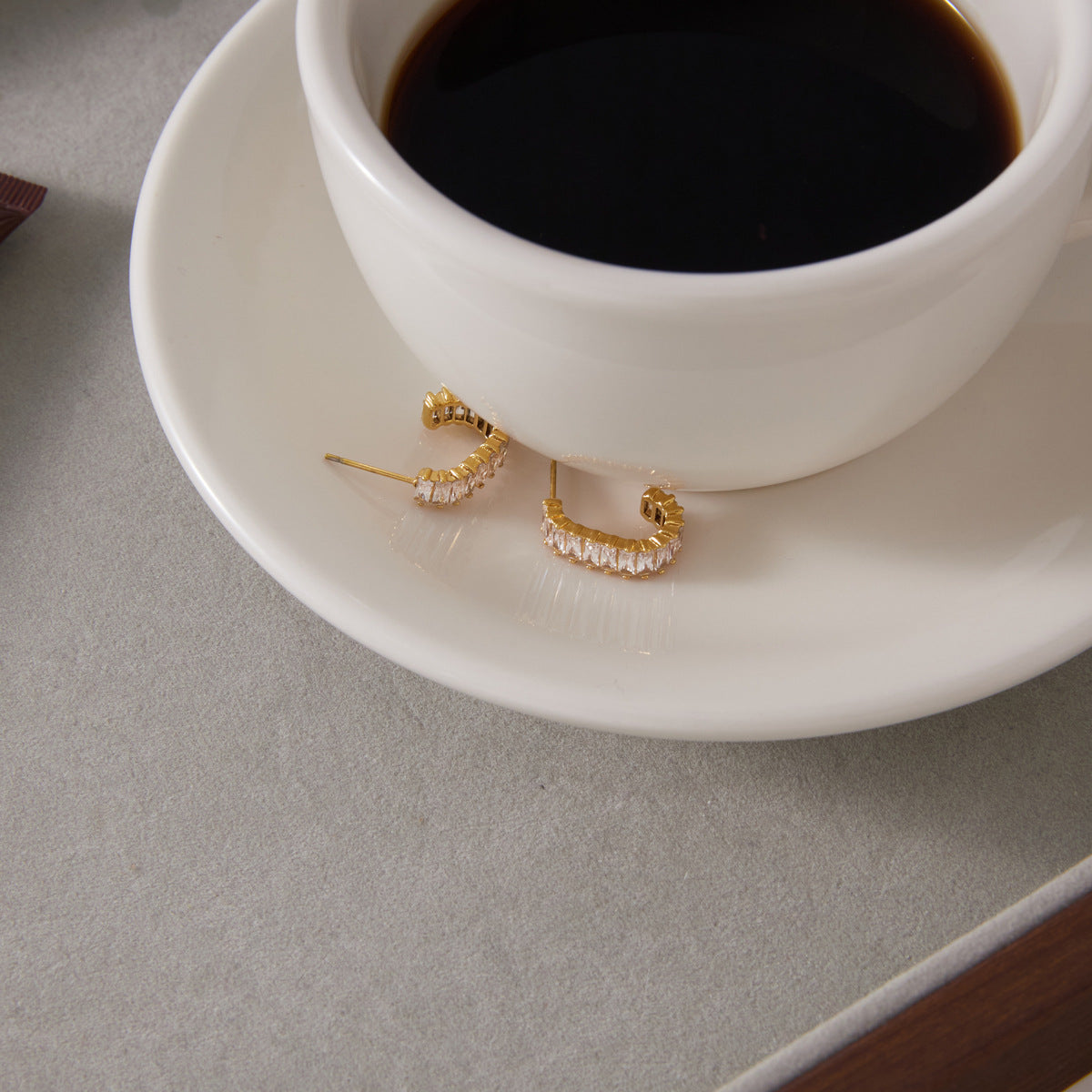Zirconia hoops displayed beside a coffee cup