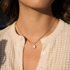 clear stone pendant necklace worn at the collarbone