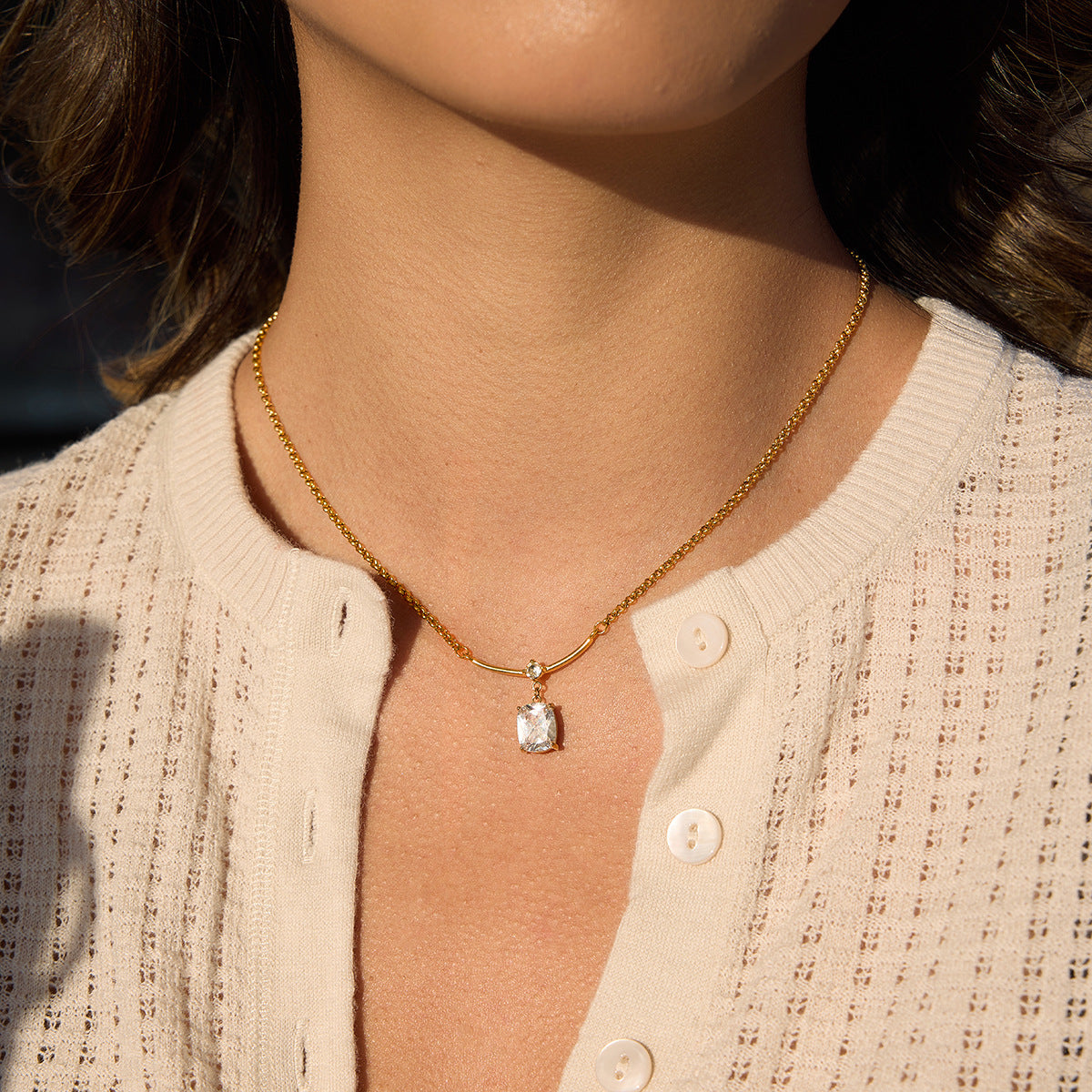 clear stone pendant necklace worn at the collarbone