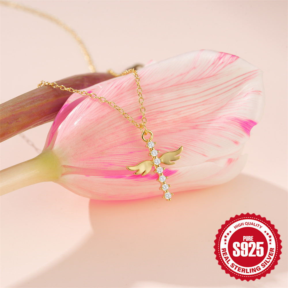 angel wing zirconia pendant necklace displayed over a pink flower