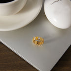 Gold-tone stone band beside a cup