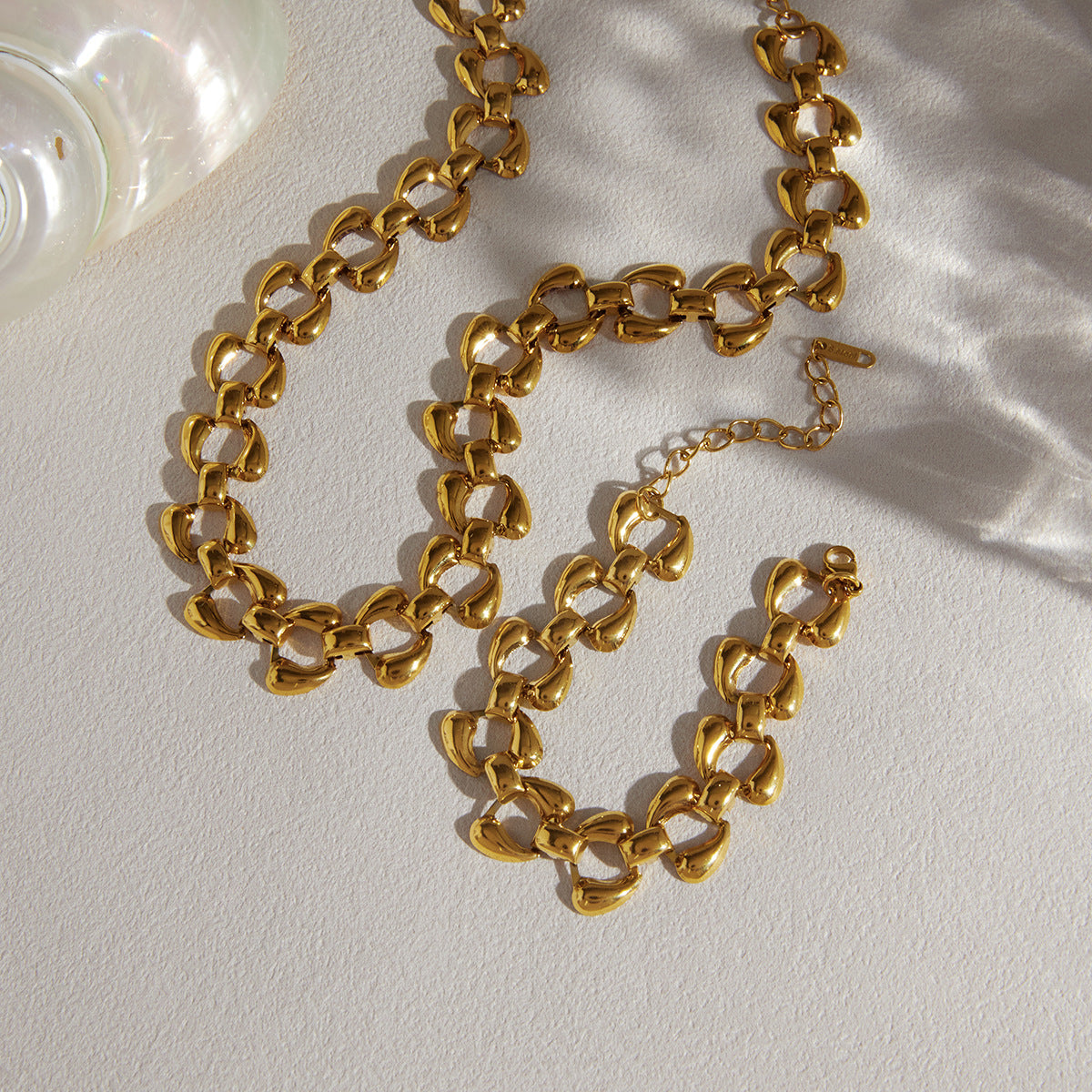 Curved-link gold-tone necklace and bracelet arranged together