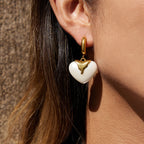 model wearing gold plated huggie earrings with ivory resin hearts