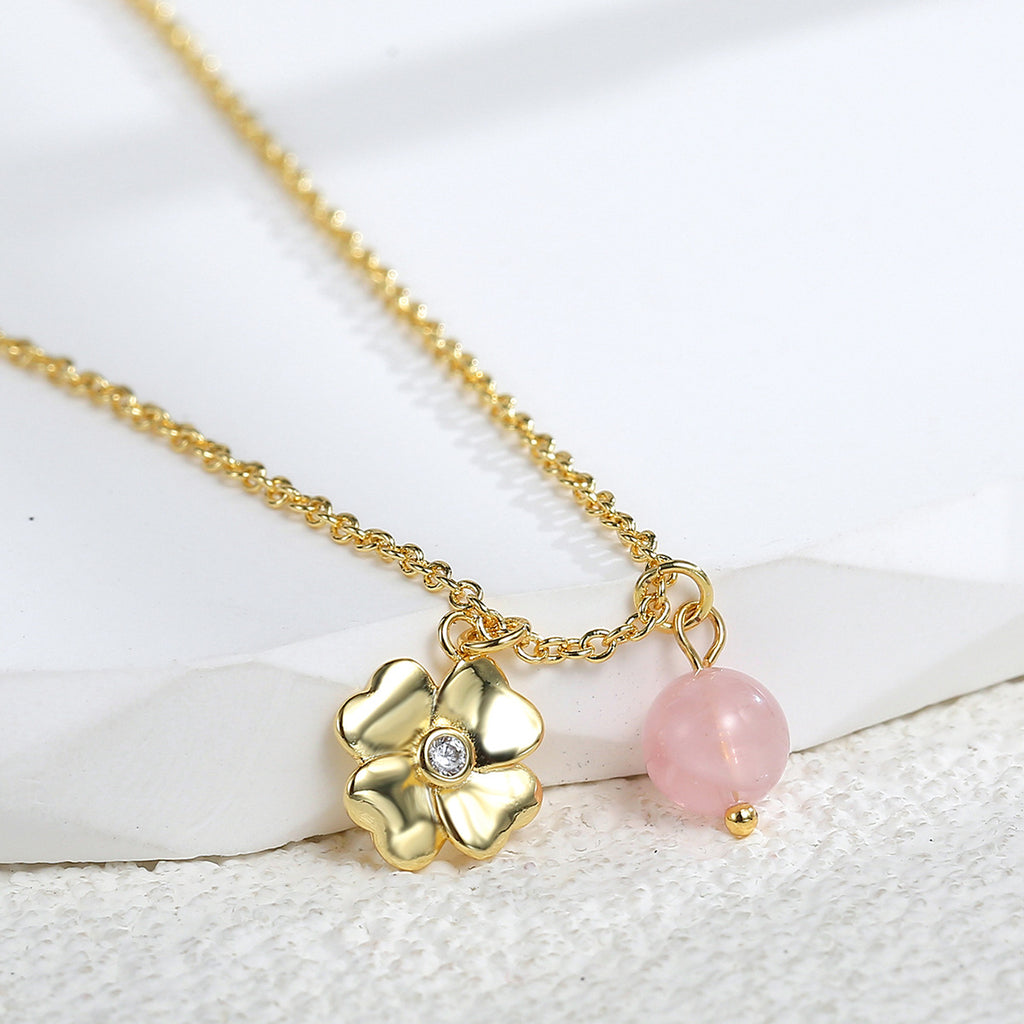 close view of the sculpted flower pendant and round pink quartz bead