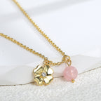close view of the sculpted flower pendant and round pink quartz bead