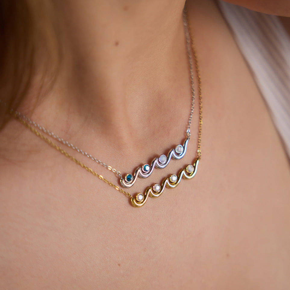 Gold and silver tone wave necklaces worn together