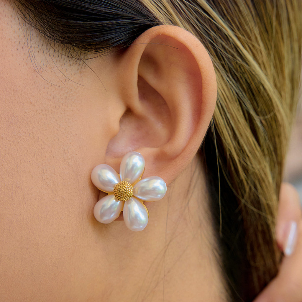 White petal flower stud earring worn at the ear