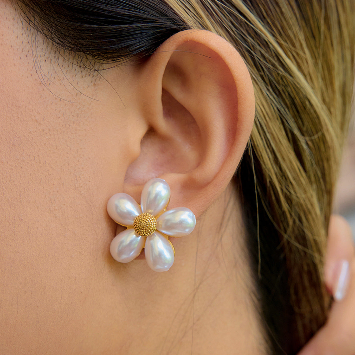White petal flower stud earring worn at the ear