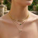 Snake and green stone bar necklaces layered with a separate chain
