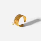 Side view of the textured gold plated band and hanging white bead