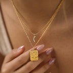 Sun pendant and crescent necklace close-up at neckline