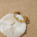 Cowrie-shell cuff on textured white surface