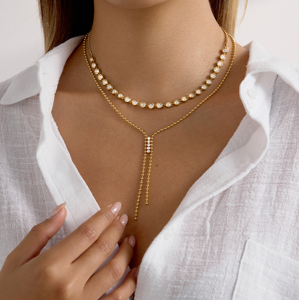 Clear accent Y necklace styled below a separate pearl-look necklace