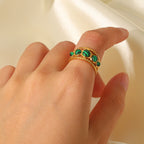 Gold plated triple green stone open ring worn on a hand