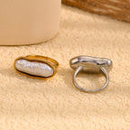 paired stainless steel elongated pearl rings shown from above and behind