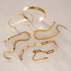 Five gold-tone bracelet styles arranged on stone
