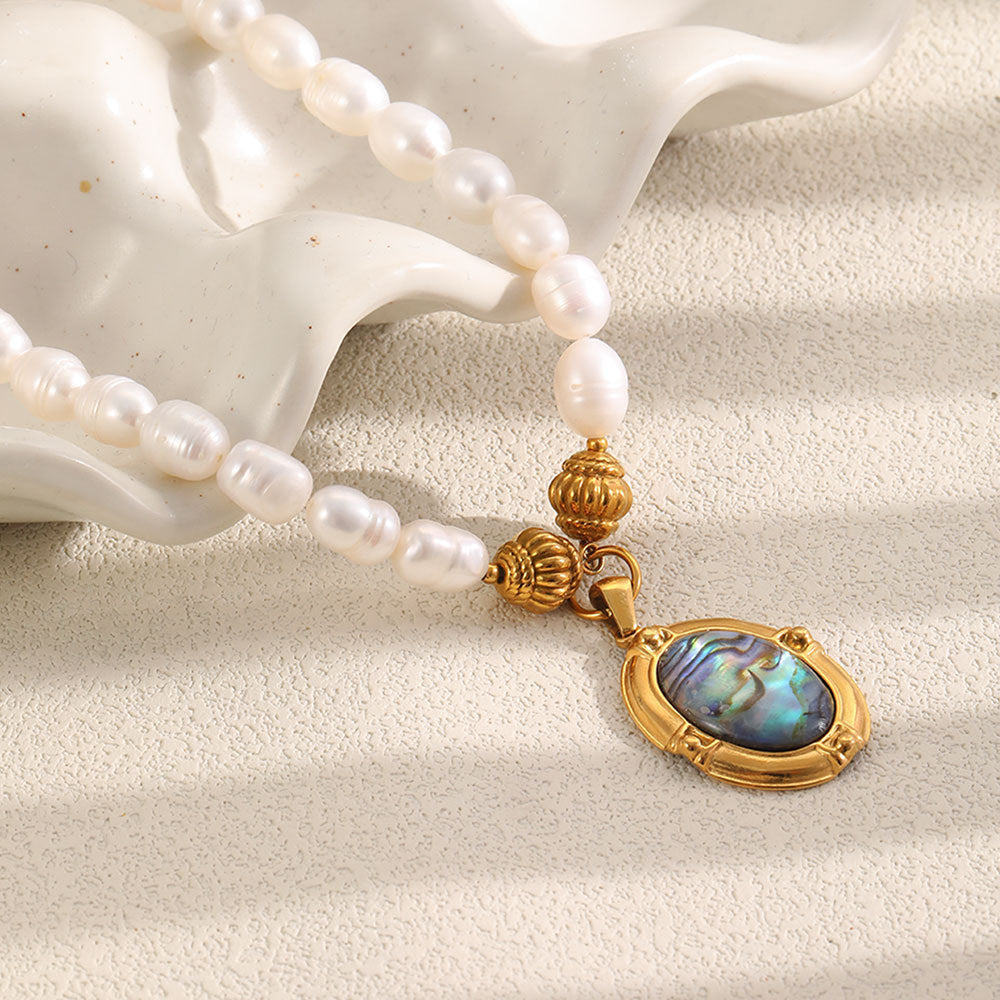 white bead necklace displayed on a sculptural ceramic surface