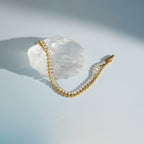Double-row bracelet displayed on a clear stone prop
