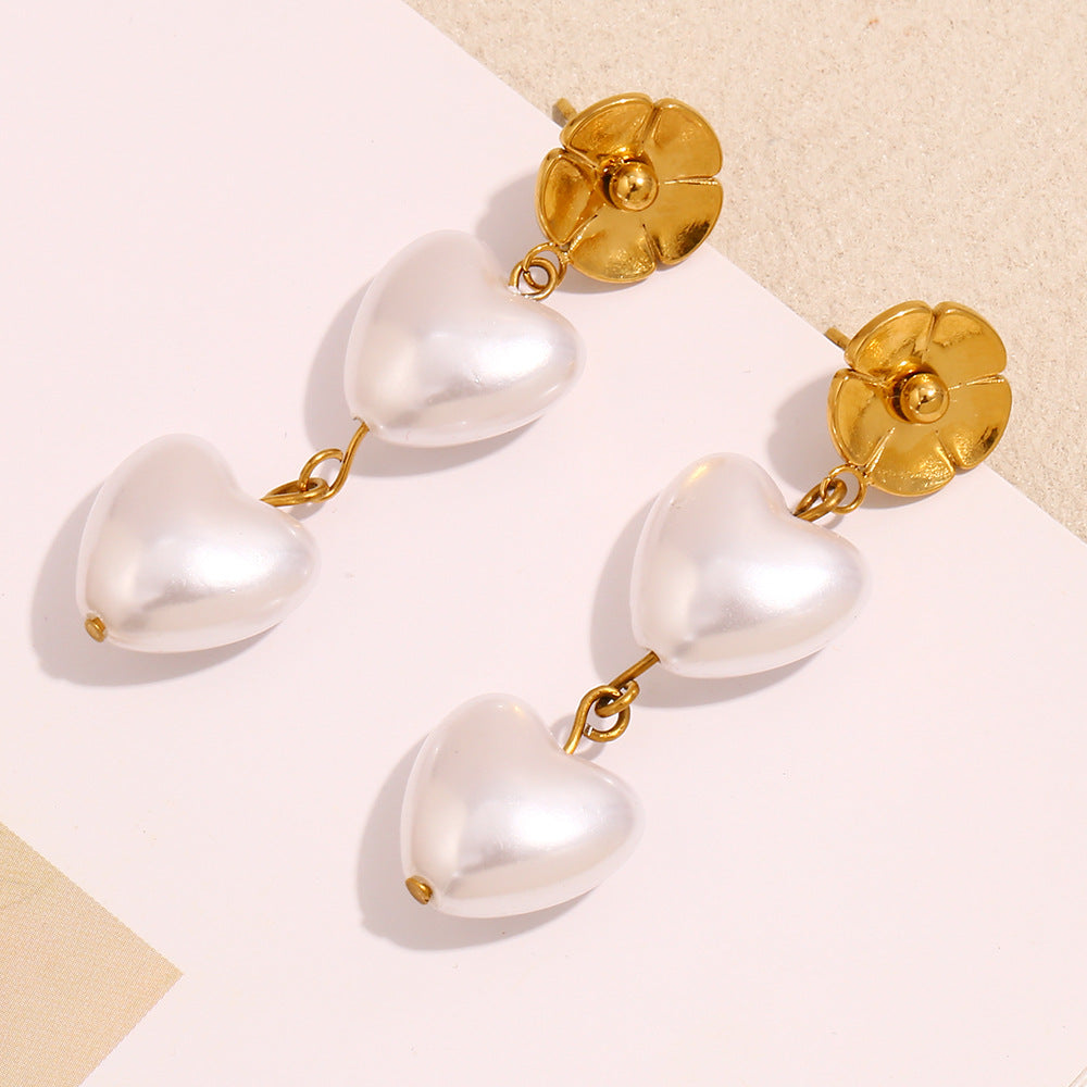 white heart-shaped pearl beads below polished flower studs