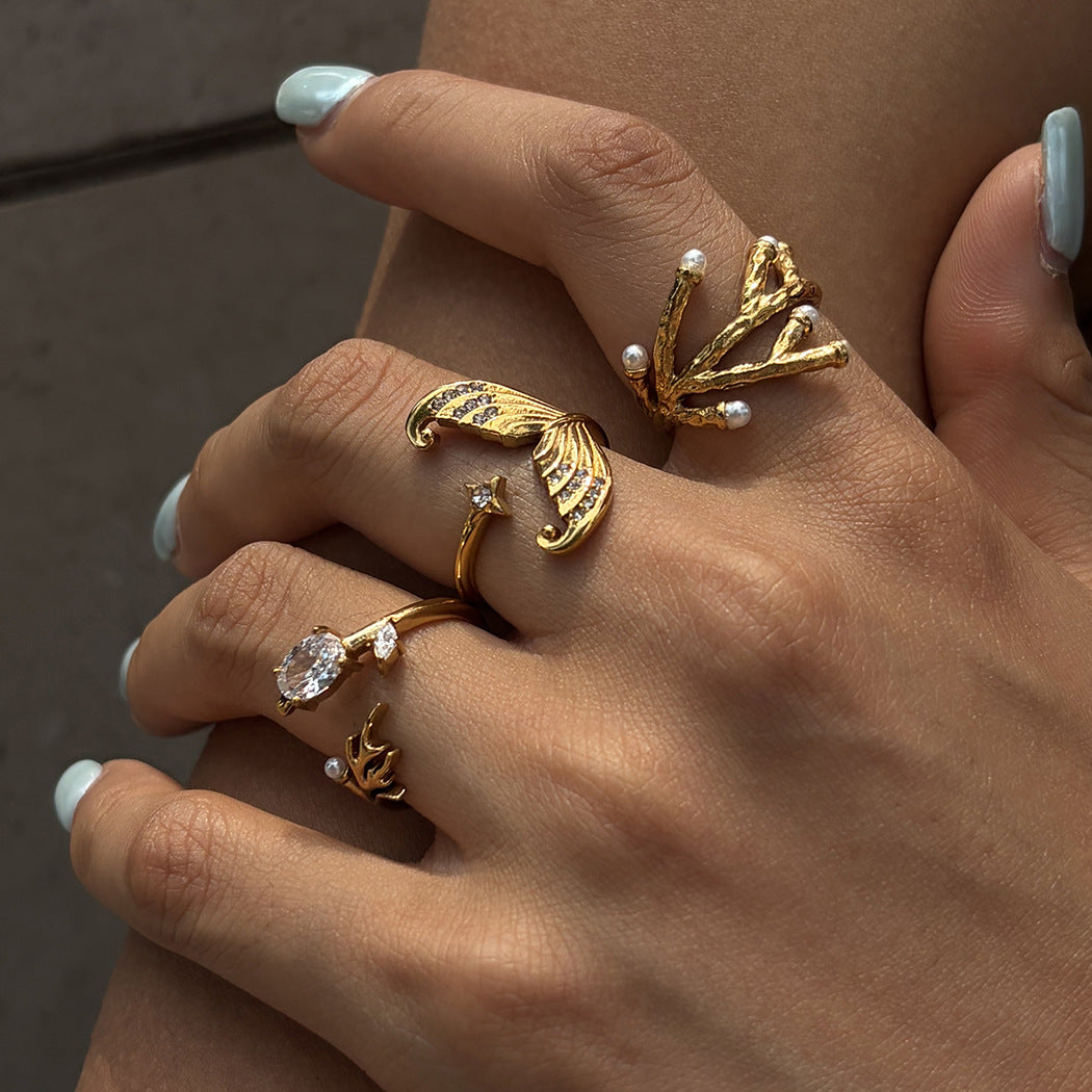 Coral and mermaid-tail rings worn together