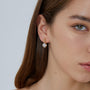 gold plated floral halo zirconia drop earrings worn on the ear