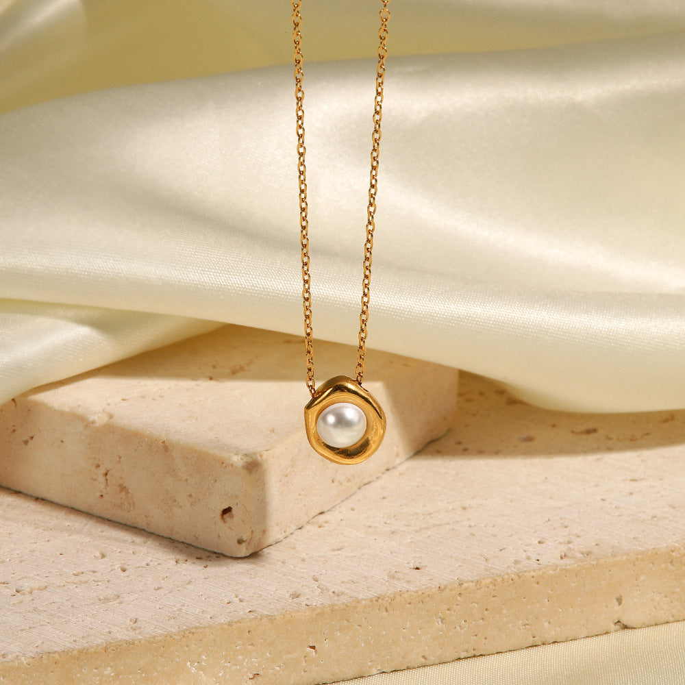 Wavy gold-tone pendant with a white center against pale stone
