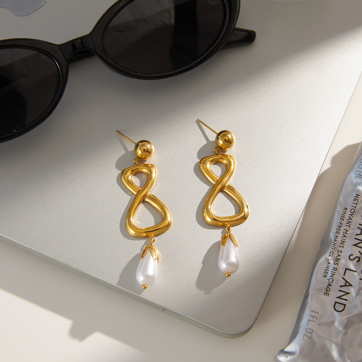 Gold-tone infinity earrings styled on display