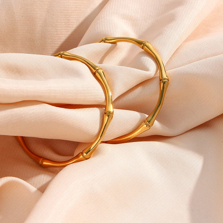 Gold plated bamboo hoops on pale fabric
