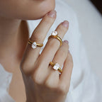 Gold-tone ribbed solitaire rings worn across three fingers