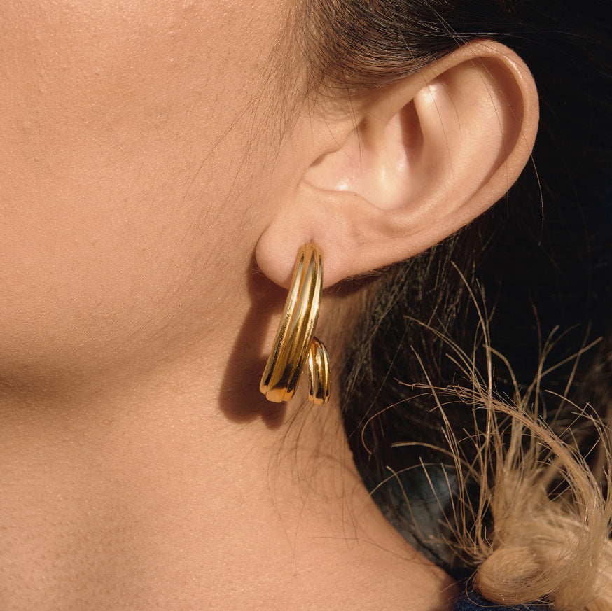 gold plated triple-strand spiral hoop earring worn from the side