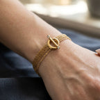 Multi-strand stainless steel bracelet with toggle worn on wrist