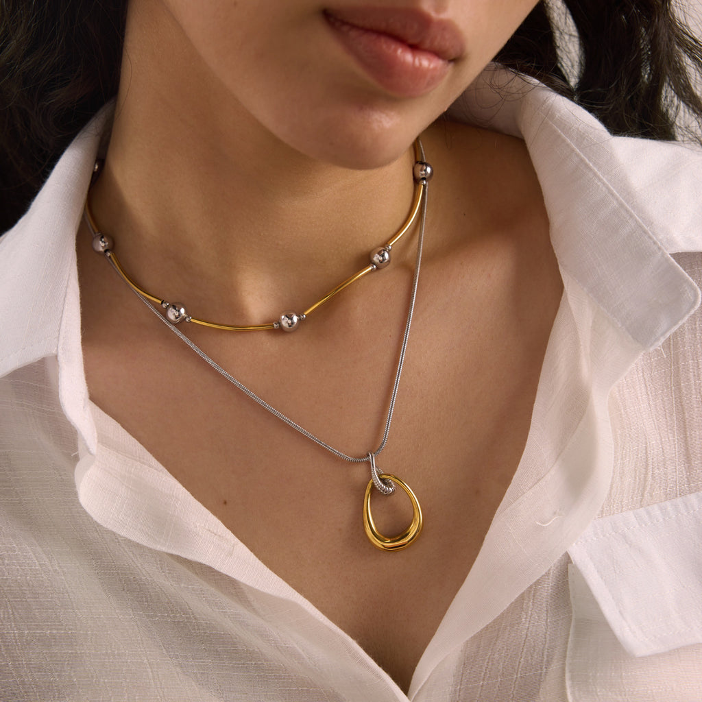 Two-tone pendant necklace layered with a separate short necklace