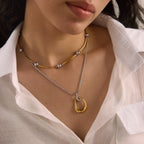 Two-tone pendant necklace layered with a separate short necklace