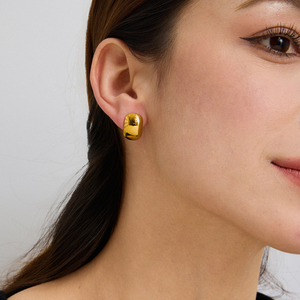 gold plated rounded dome stud earring worn on the ear