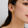 gold plated rounded dome stud earring worn on the ear